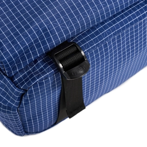 Close-up of blue ripstop fabric texture and black plastic buckle with CLBD engraving