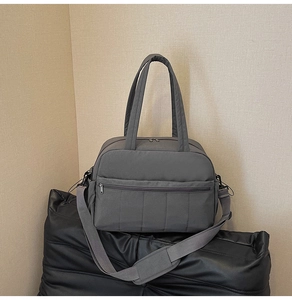 Detail view of large mauve travel bag with zip pocket and adjustable wide shoulder strap