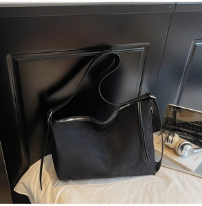 Detail of matte black tote bag showing premium brushed leather texture and wide strap