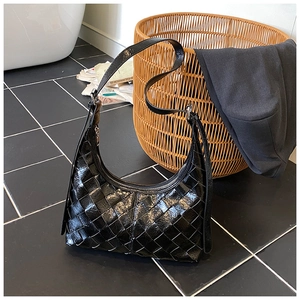 Detail der schwarzen geflochtenen Hobo-Tasche mit Reißverschluss und verstellbarem Gurt