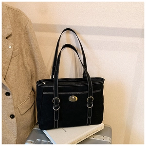 Detail of black canvas tote bag with white stitching and silver rotary buckle