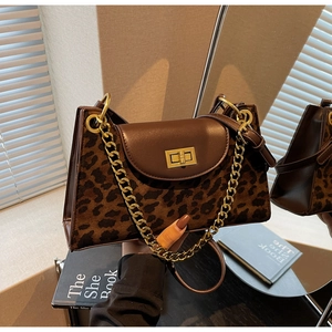 Detail of vintage leopard print bag showing brown leather, leopard faux fur and gold chain