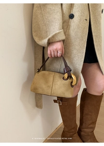 Detail of khaki suede Boston bag with large gold buckle and leather handle