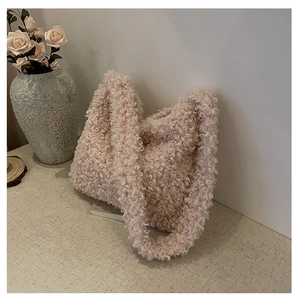 Close-up of soft apricot plush shoulder bag with curly faux shearling texture and strap