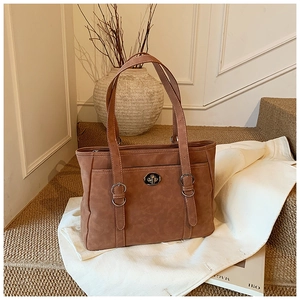 Detail of caramel suede tote bag featuring a metallic swivel lock and large capacity