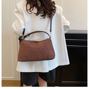 Business style minimalist brown suede tote bag carried by model in white suit