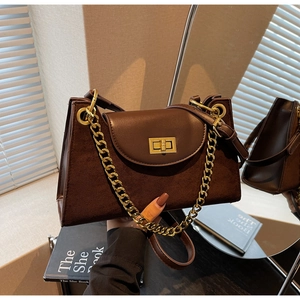 Detail of vintage matte brown shoulder bag with gold chain strap and metal lock closure