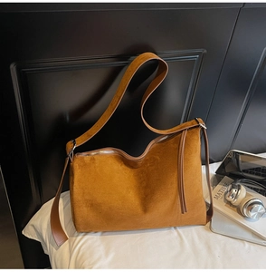 Detailed view of caramel suede tote bag with silver zipper and tassel puller