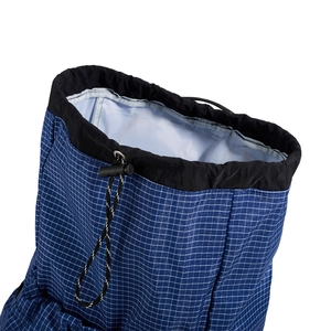 Detail of blue grid fabric drawstring closure with black stopper on outdoor backpack