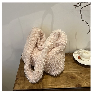 Close-up of fluffy cream plush tote bag on a wooden table with cozy winter aesthetic