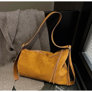 Macro detail of mustard yellow suede tote bag with fringe zipper and leather strap
