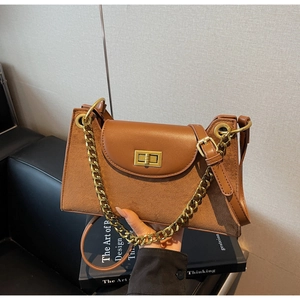 Close-up of caramel brown frosted suede bag with gold chain and metal twist lock