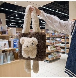Dettaglio borsa tote marrone in peluche con un grazioso orsetto bianco in lana di agnello