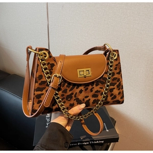 Detail of leopard print suede texture with brown leather flap and gold chain strap