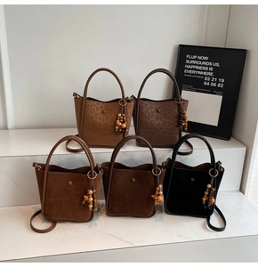 Detailed row of suede bucket bags with beaded charms and adjustable shoulder straps