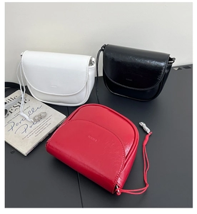 Detailed macro view of minimalist leather saddle bags in red, black, and white colors