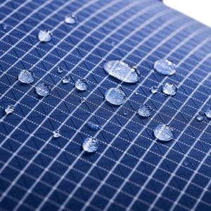 Macro view of blue ripstop fabric with waterproof coating and water droplets