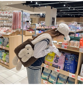 Dettaglio di una borsa tote in peluche marrone con orsetto bianco e manici soffici