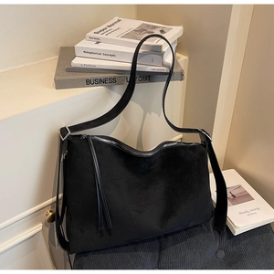 Detail of adjustable silver buckle on black matte leather hobo bag strap