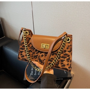 Detail of leopard print crossbody bag with golden metal lock and smooth leather strap