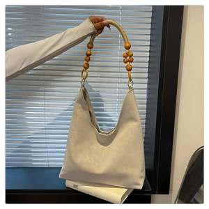 Close-up of a large tote bag with a unique cotton-wrapped handle and wood bead accents