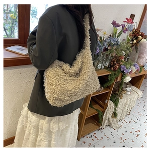 Model wearing a soft cream plush tote bag in a cozy vintage interior setting