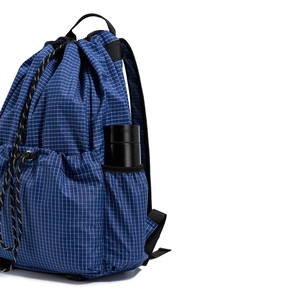 Close-up of blue textured drawstring backpack with side pocket and black water bottle