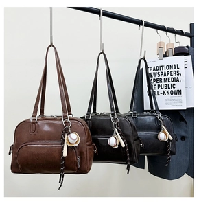 Detail of vintage tote bag with baseball bat charm and retro matte leather finish