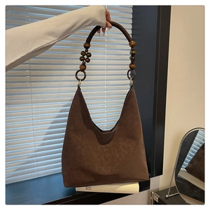Close-up of brown hobo bag with unique wooden bead handle and soft matte suede texture