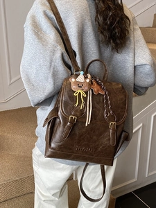 Vintage brown leather backpack with retro flap and cute bear pendant accessory