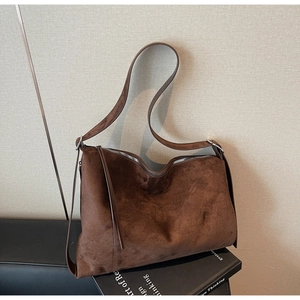 Macro shot of large dark brown suede tote bag with metal zipper and long leather puller