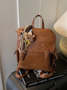 Retro brown faux leather backpack with plush bear charm and vintage aesthetic