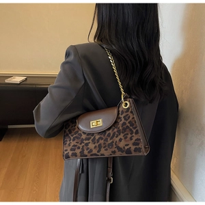 Detail of retro shoulder bag with leopard print, brown leather, and gold chain strap