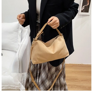 Detail view of khaki suede tote bag worn by model showing size and soft texture