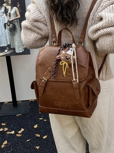 Vintage brown leather backpack for women featuring flap buckle and cute bear pendant