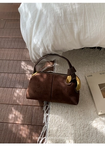 Detail of Boston bag showing dark coffee suede texture and gold vintage metal hardware