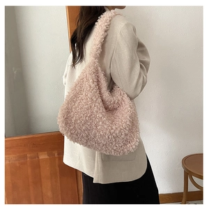 Detail view of pink plush hobo bag showing soft fleece texture and wide shoulder strap style