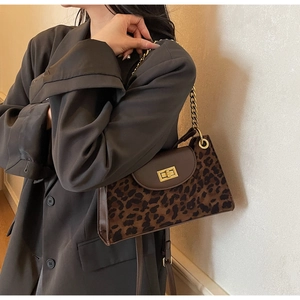 Detail view of leopard print shoulder bag with gold chain strap and metal lock closure