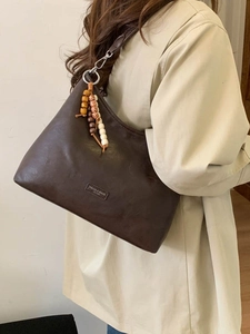 Retro dark brown leather shoulder bag with colorful wooden beads on white background