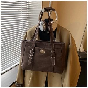 Detail of vintage brown suede tote bag with silver twist lock and adjustable straps