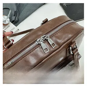 Detail of smooth silver metal double zippers on a dark brown leather tote bag