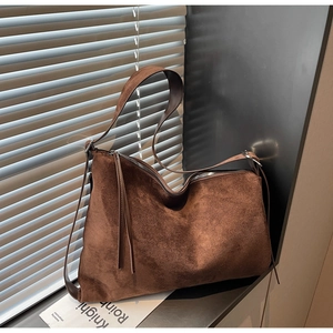 Detail of vintage brown suede tote bag with smooth metal zipper and wide flat shoulder strap