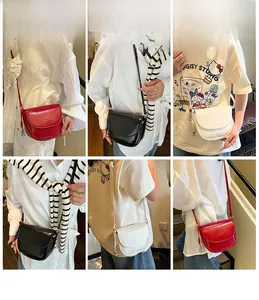 Detail view of minimalist half-round crossbody saddle bags in red black and white colors