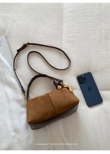 Detail showing retro brown suede and leather patchwork with gold buckle on a Boston bag