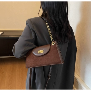 Detail of vintage brown frosted leather shoulder bag with gold square buckle and chain strap