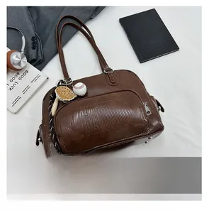 Flat lay of retro brown tote bag with embossed pocket and baseball charm details