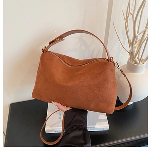 Detail of caramel brown suede texture and golden zipper on the stylish commuter tote bag