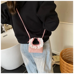 Pink mini crossbody bag featuring white lace ruffle handle on model back view