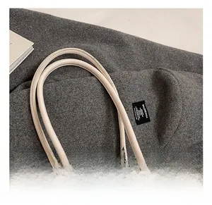 Detail of soft cream leather handles with silver metal buckles on a vintage tote bag
