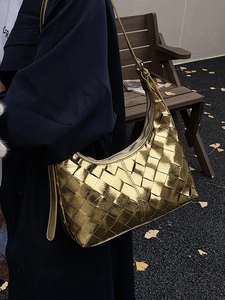 Metallisch goldene geflochtene Hobo-Tasche mit verstellbarem Gurt am Modell getragen